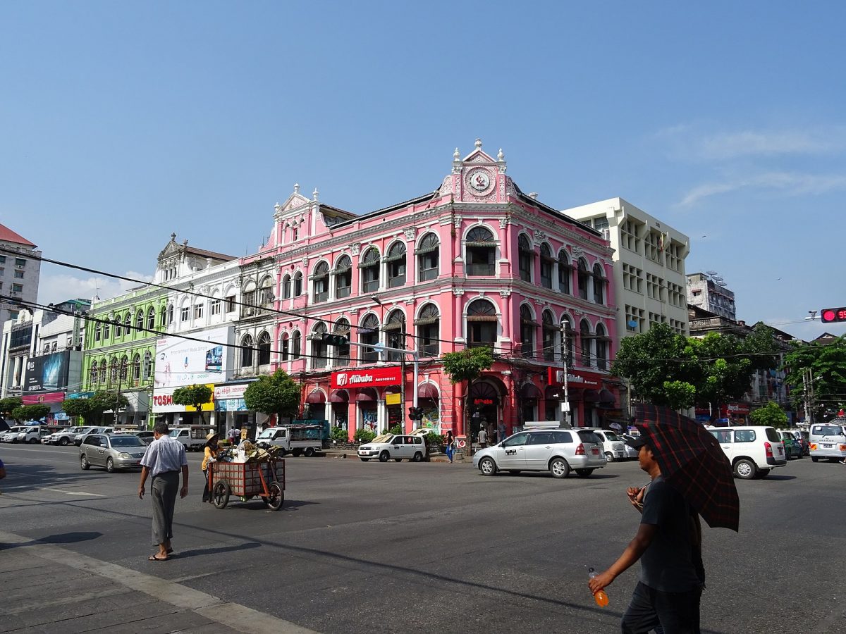 driving cars and people walking at the busy Pansodan Street in Yangon