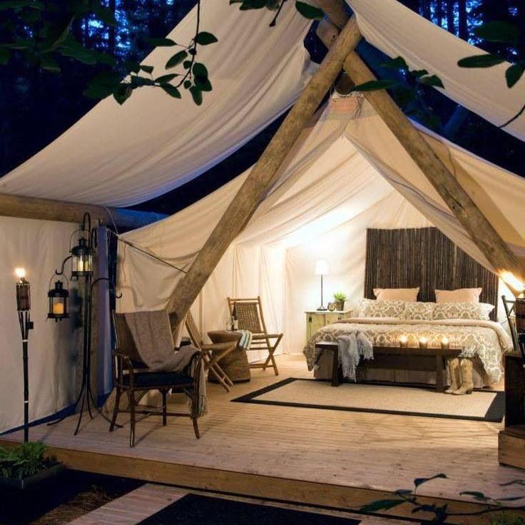 Safari-inspired tent with mattress, lounge chairs, and other amenities
