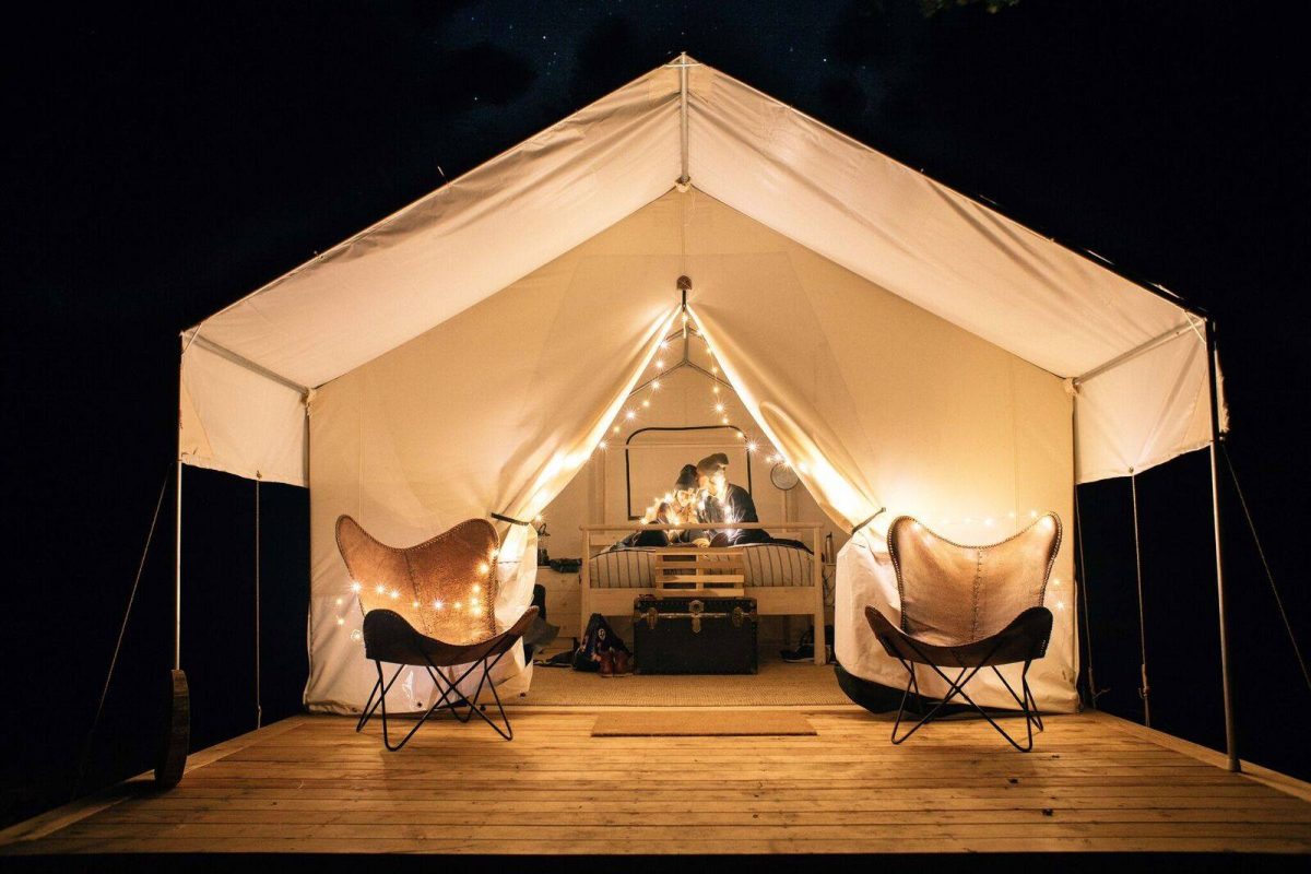 Glamping tent lit up with golden light bulbs
