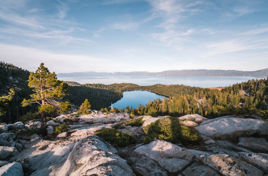 Rock formations and trees surround the blue waters of Lake Tahoe